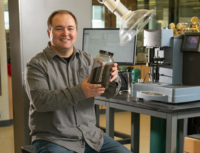 Student in lab holding glass jar
