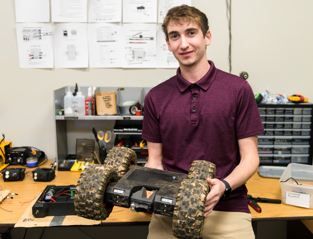 STUDENT HOLDING A REMOTE CONTROL CAR