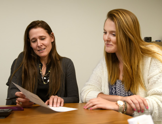 Two women talking at desk