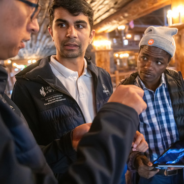 Three engineering students talking in a factory