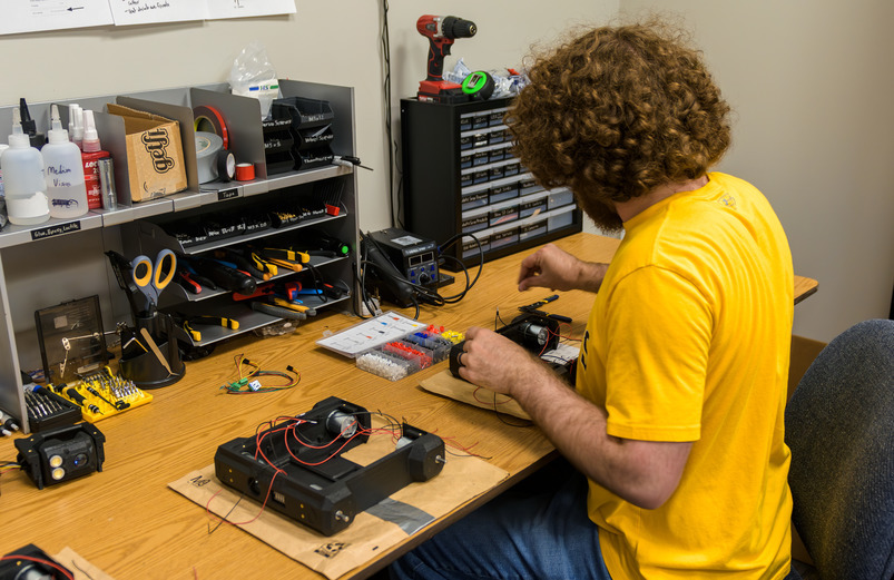 Student working at desk with machine parts