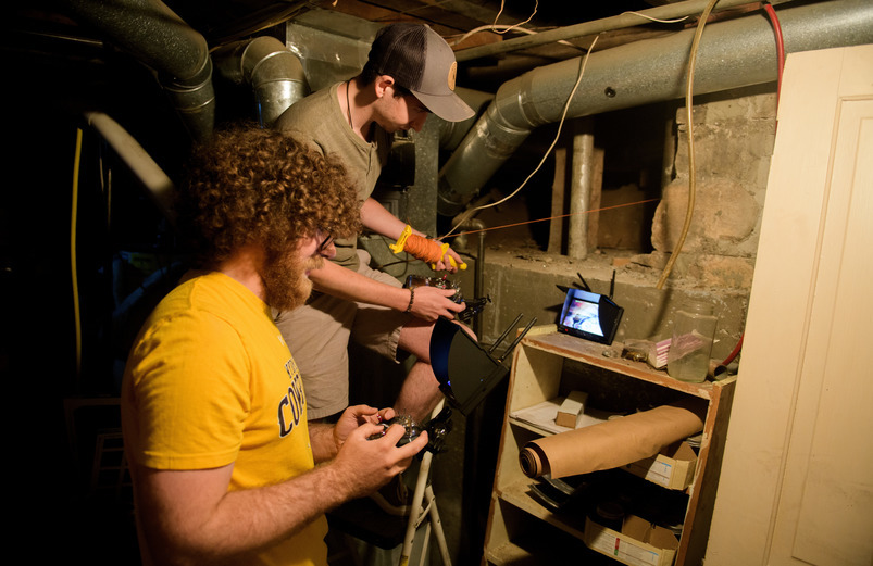 Two students workin gby a pipe