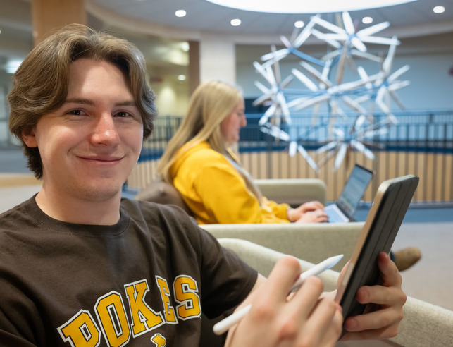 Student on tablet, smiling