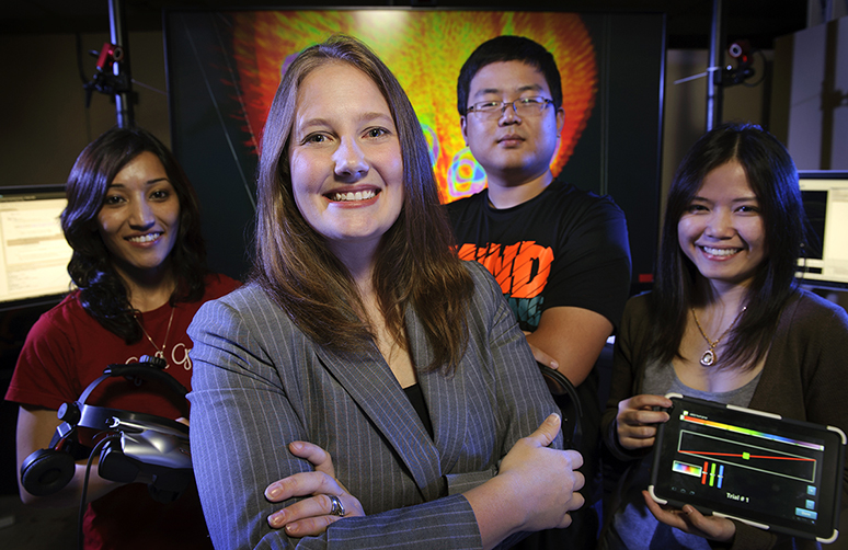 A group of UW students in the lab smile at camera.