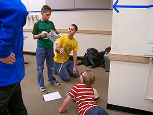 students working together on floor with measuring tape
