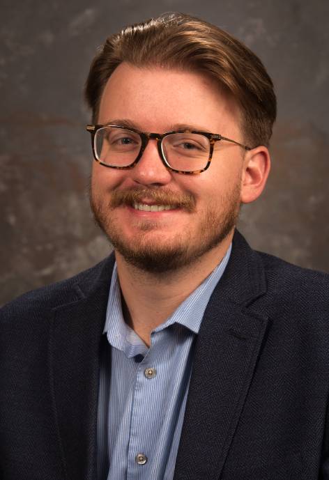 An image of Ian Hammontree in front of a brown background