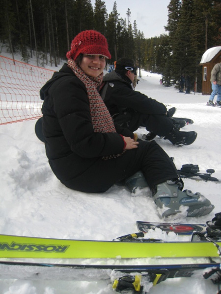 Student sitting in snow smiling