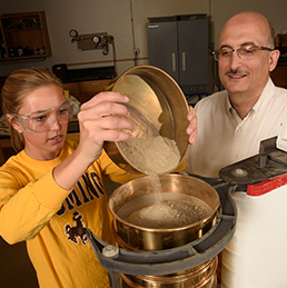 Khaled Ksaibati (right) and civil engineering student Kristen Debler test road materials.