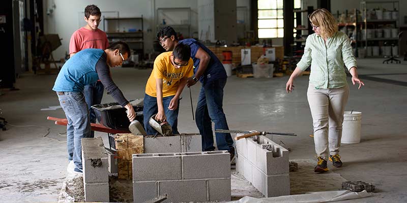 Jennifer Tanner directs students in building a beam for structures testing.