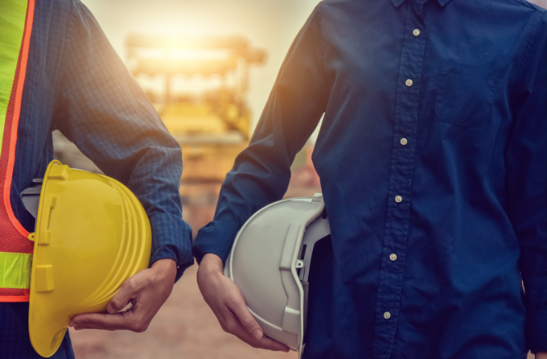 two people holding hard hats