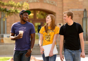 Three students conversing in front of the UW Union