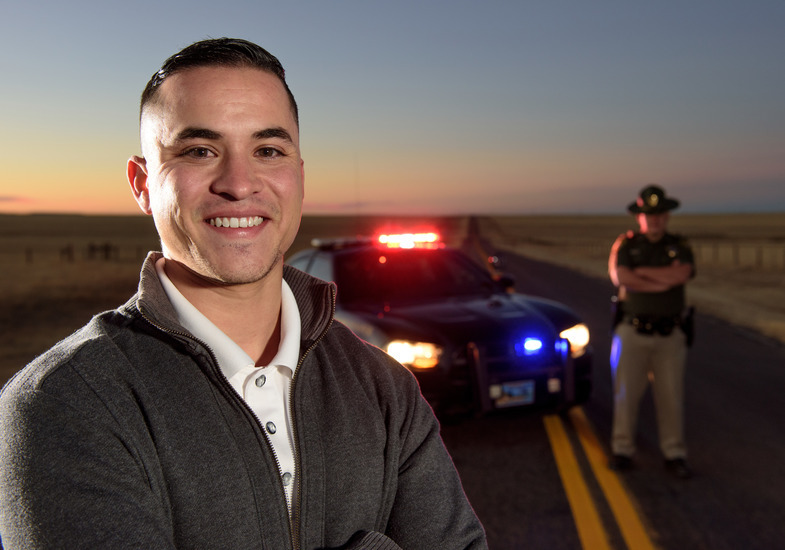 Man standing in front of Police car and Police Officer