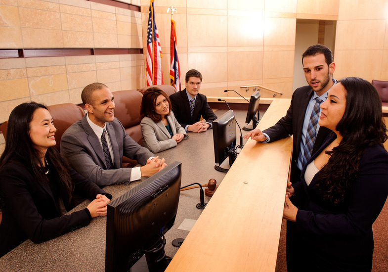A group of people speaking in a courtroom