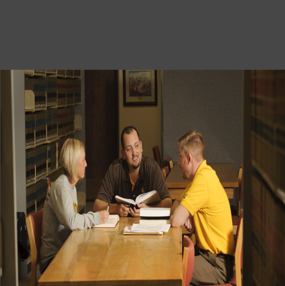 Students sitting at a table reading 