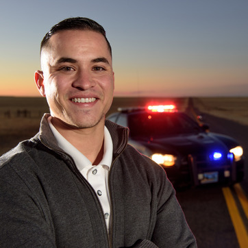 man stands in front of police car