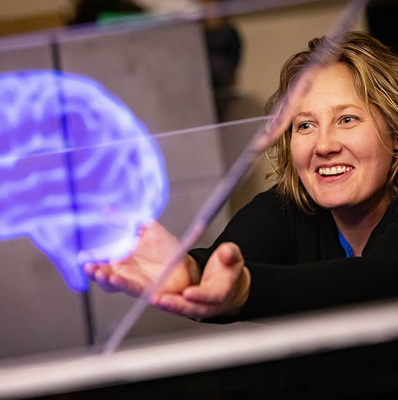 Student interacting with 3D rendering of brain