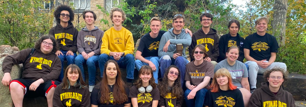 UW debate team sitting together and smiling