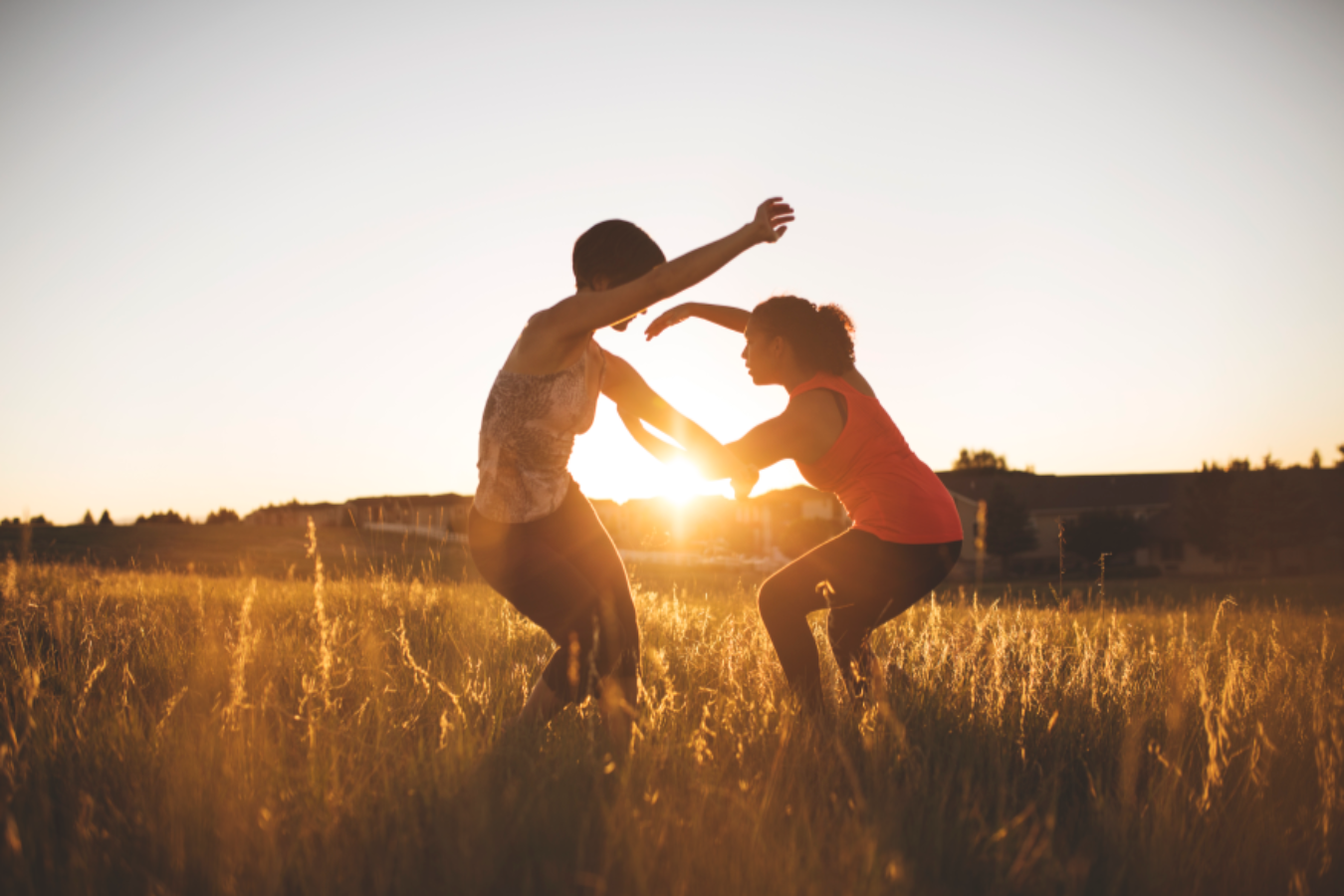 Two people dancing at sunset