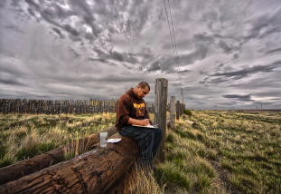 student writing in the prairie