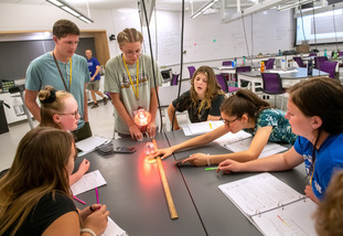 UW students from a student organization work together on a hands-on activity surrounding a table