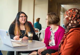 Three UW community members sit around a table and have a discussion.