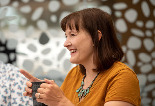 A UW faculty member smiles as they meet with a faculty support group.