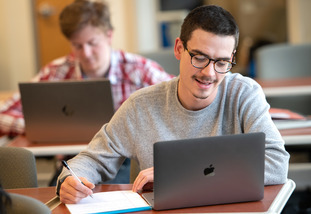 A UW student works on coursework on their laptop for a University of Wyoming class.