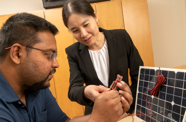 Two people viewing a microchip