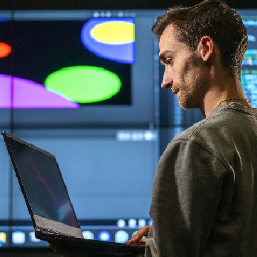 man with laptop infront of a projected computer screen