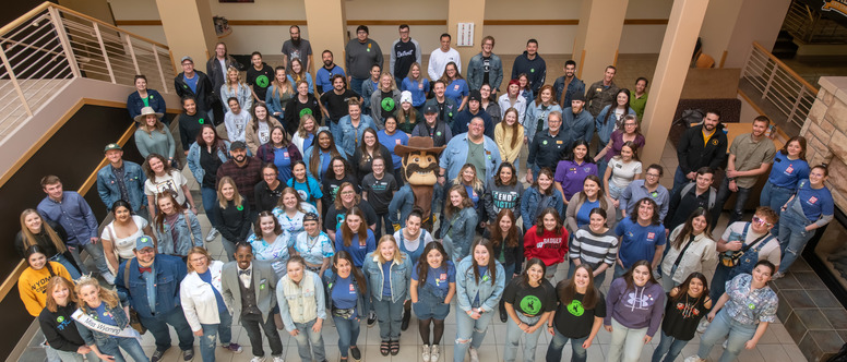 Group of people standing in the UW Union all looking at the camera.