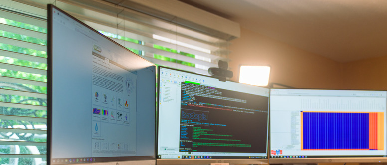 Three computer screens with code on them