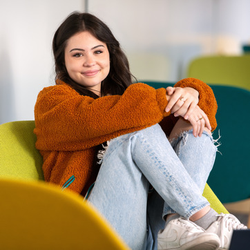 Female student sitting on a chair, smiling