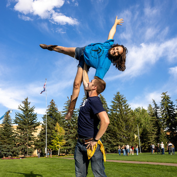 Male student holding female student in the air