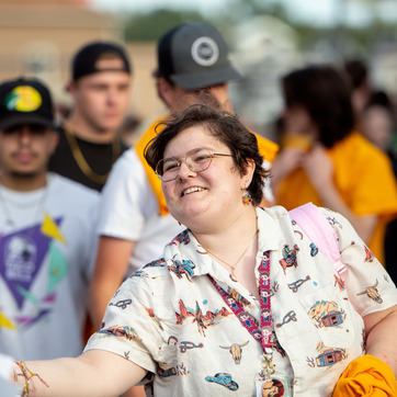 Student smiling and reaching out at football game