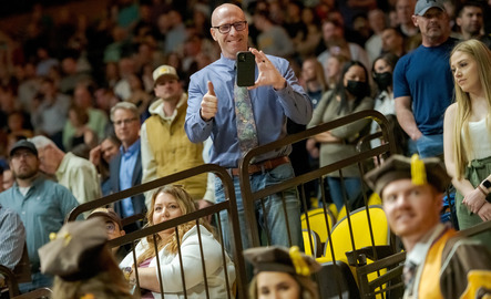 A parent of a UW graduate smiles and gives a thumbs up during a University of Wyoming commencement.