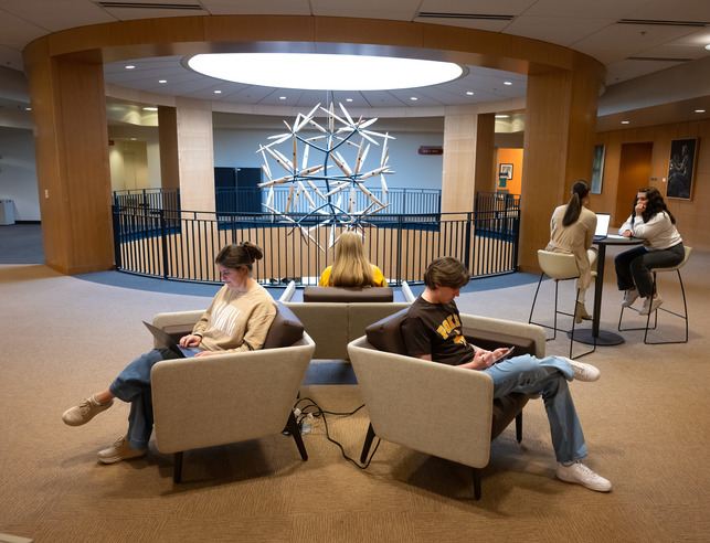 Two students sitting in comfy chairs
