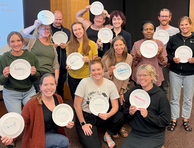 Students posing with paper plates written on them