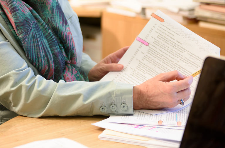 a person is holding documents and pointing out something on the document
