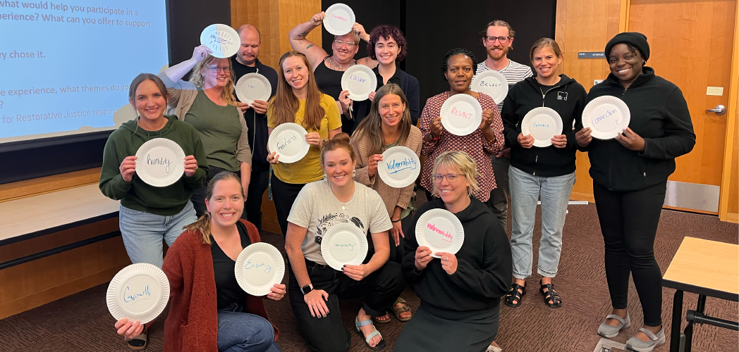 People holding up their activity craft from a Restorative Justice gathering.