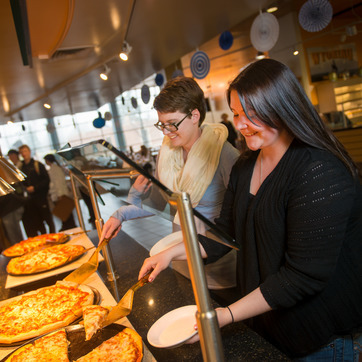 UW students serve themselves slices of pizza from the University of Wyoming Washakie Dining Hall.