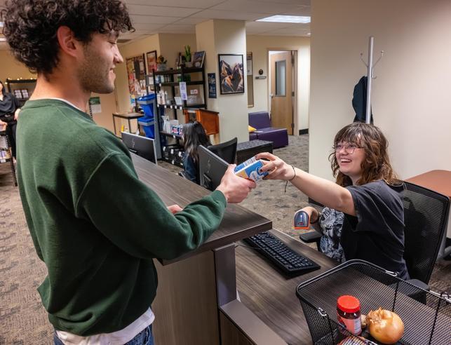 Student checking out his food items from the pantry at the PCCR desk