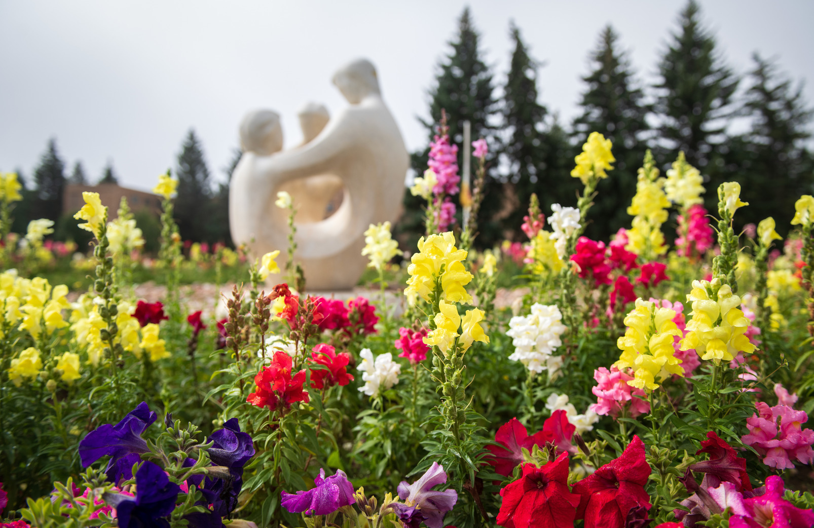 Family statue with colorful flowers in the foreground