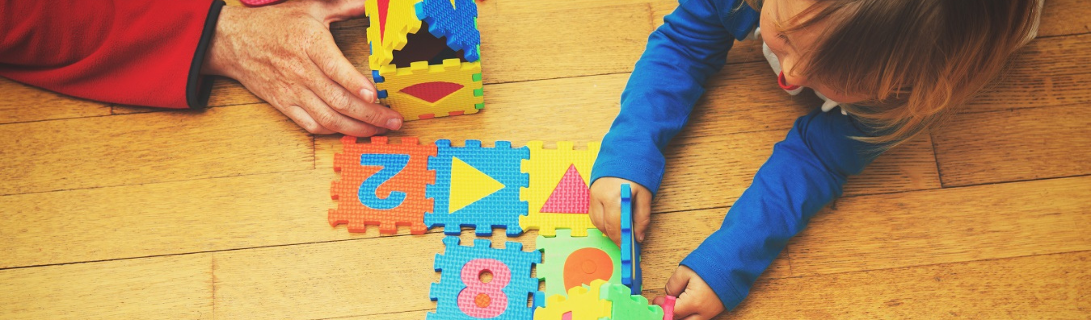 Child putting together a floor puzzle