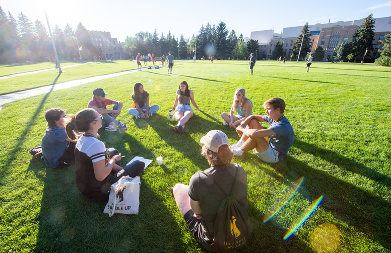 Student sit on a circle on Prexy's Pasture