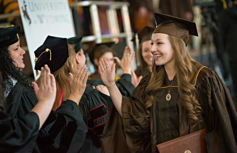 Students giving high fives at graduation ceremony