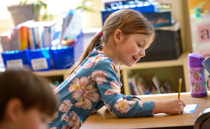 Young child writing at her desk