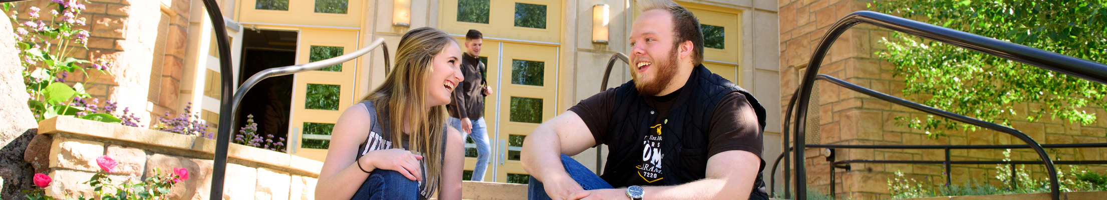 Two students chat outside the college of education