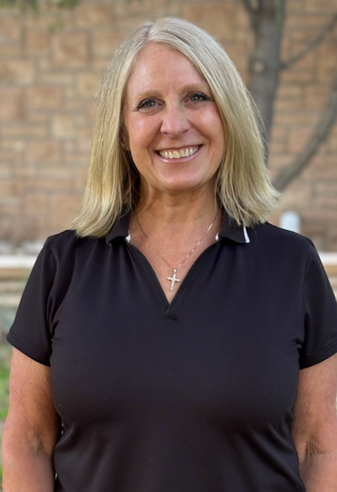 Jackie Hill in brown collard shirt standing in front of the University of Wyoming Education Building