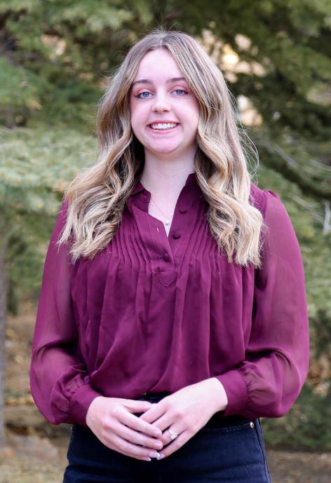 Photo of Jaydee Asay in front of trees.