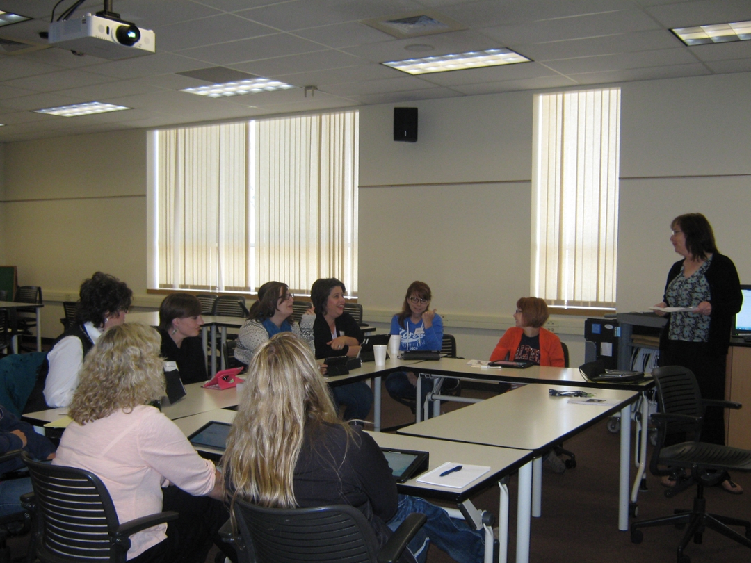 teachers around a large table watching a presentation
